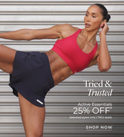Woman in black shorts, red sports bra striking active pose. Text: Tried and trusted, Active Essentials, 25% off. Selected Styles only. T&Cs apply. Shop Now