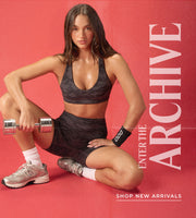 Woman in camo activewear, holding weight. Text - Enter the Archive, Shop New Arrivals