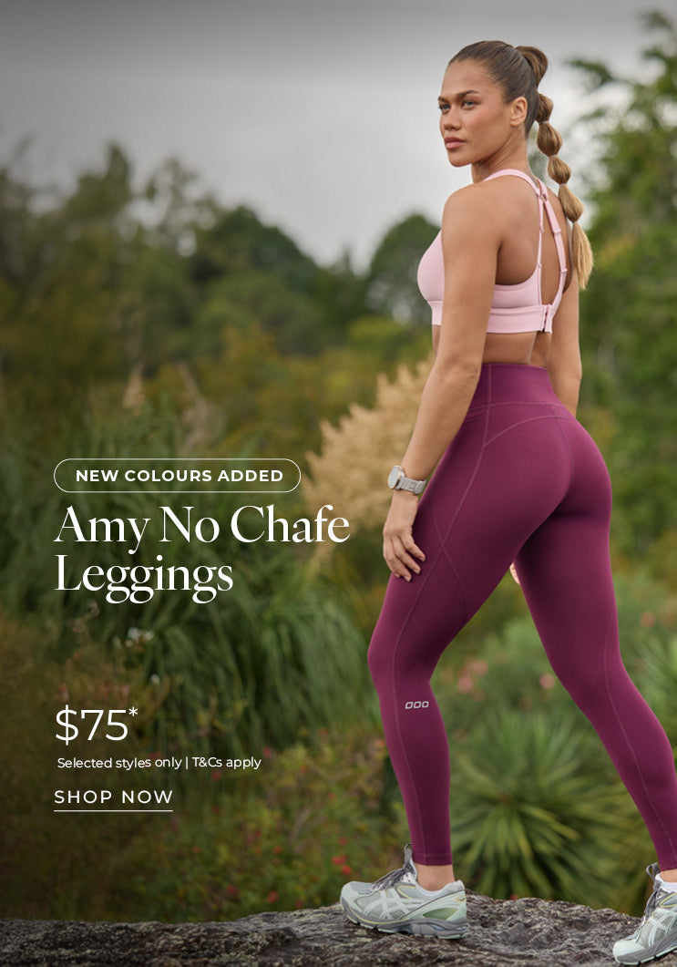 Woman standing on a rock in a natural outdoor setting, wearing a pink Lorna Jane sports bra and burgundy Amy No Chafe Leggings. Text: New Colours Added. Amy No Chafe Leggings $75* Selected styles only | T&Cs apply - Shop Now