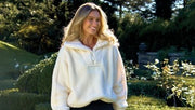 Model wearing a white zip jacket standing in a garden