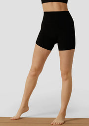 Model wearing black bike shorts standing on a yoga mat