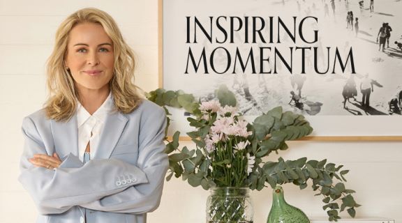 Lorna Jane Clarkson standing in front of a picture with the text Inspiring Momentum