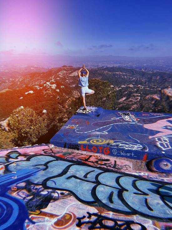 lola berry doing yoga poses in blue lorna jane activewear with colourful outdoors backdrop