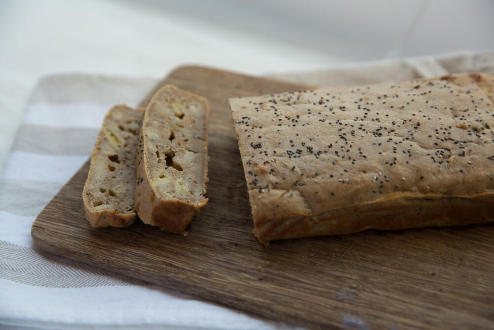banana chia seed loaf of bread freshly cooked and sliced, on chopping board