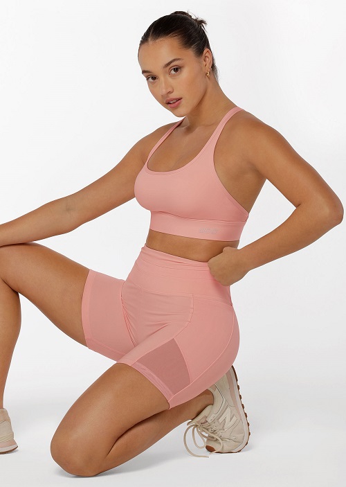 brunette model wearing compression bike shorts in blushed pink