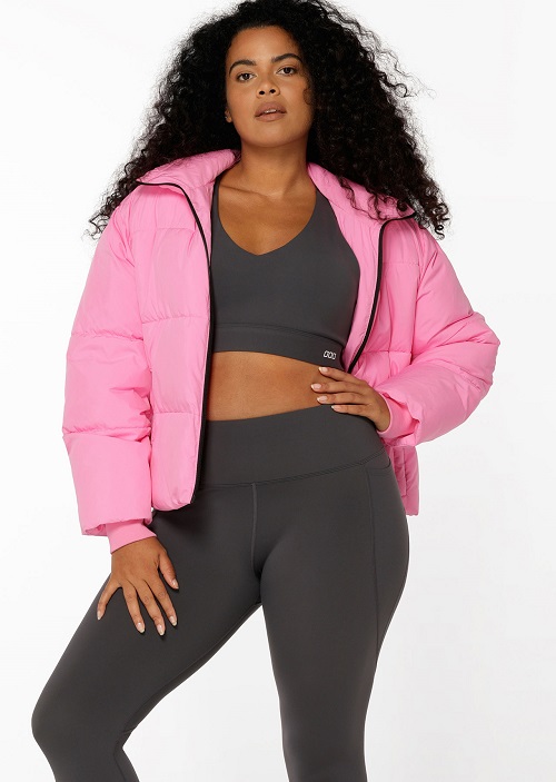 woman wearing a short pink puffer jacket and grey activewear
