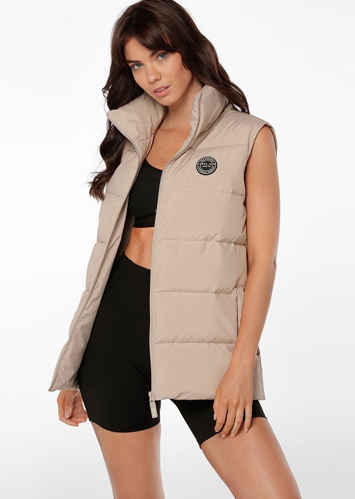 woman wearing long cream puffer vest and black activewear