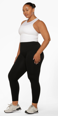 woman wearing a cropped white tank top and black ankle biter leggings