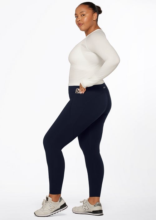 woman wearing white long sleeve top and full length navy blue thermal leggings